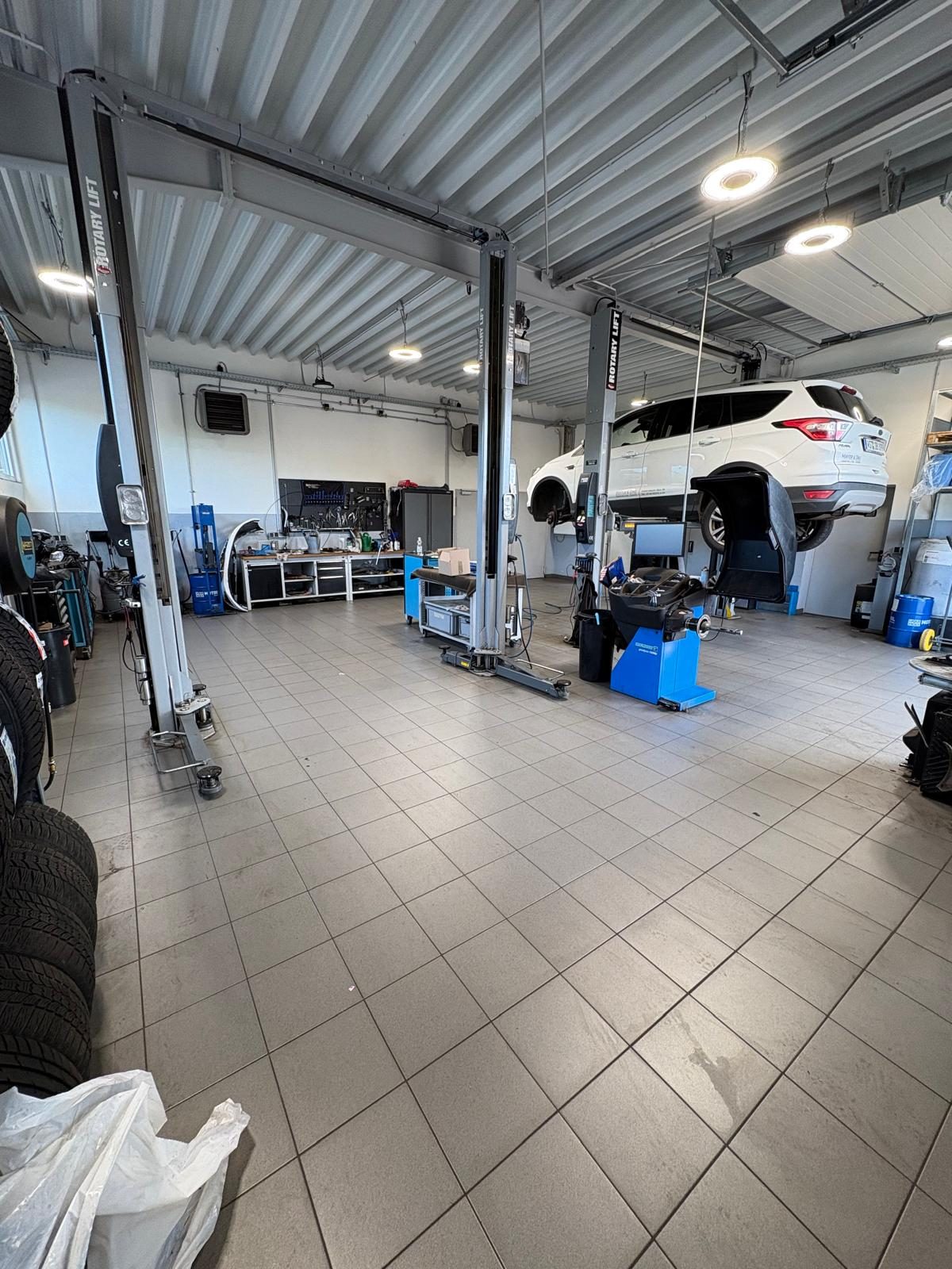 Helle, aufgeräumte Werkstatthalle mit Hebebühnen bei Auto Horn